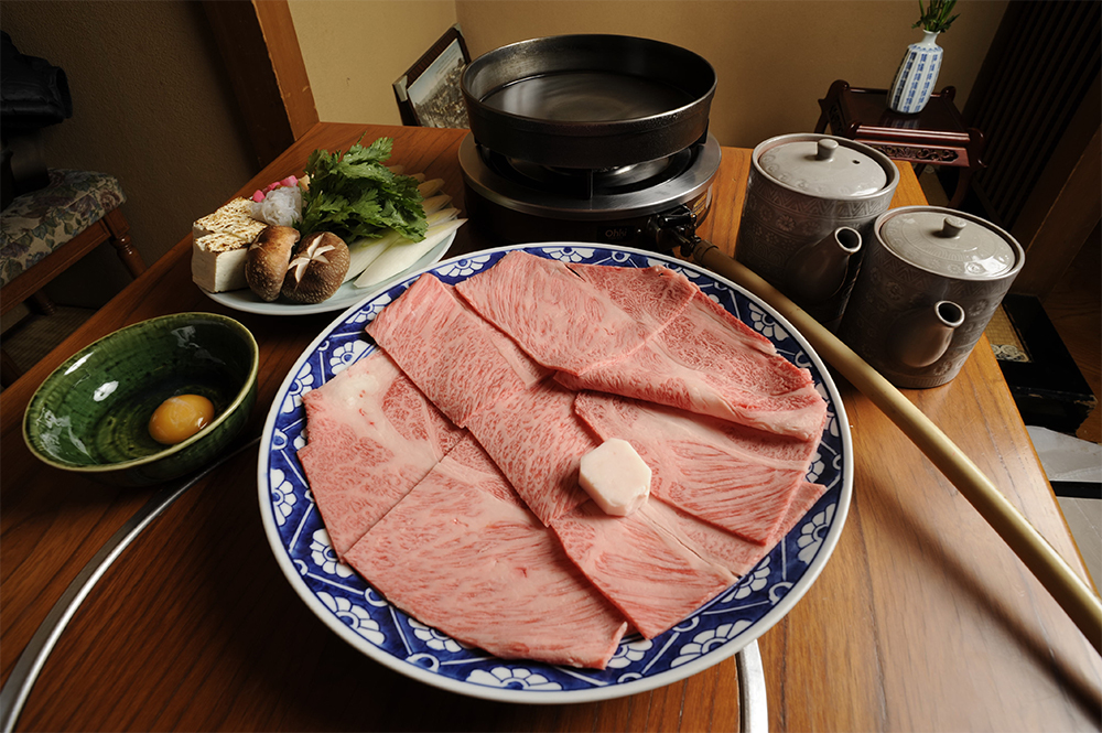 肉は1人前125g。長ネギ、春菊、焼豆腐、しらたき、椎茸、麩、卵がついて、椿3500 円、楓5000 円、桐8000 円の3 コースがある（写真は桐コース2 人前）。
