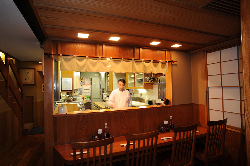 入り口すぐは4席のカウンターとオープンキッチン。料理と同じく空間にも洋と和が混じり合い、独特の雰囲気を醸し出している。