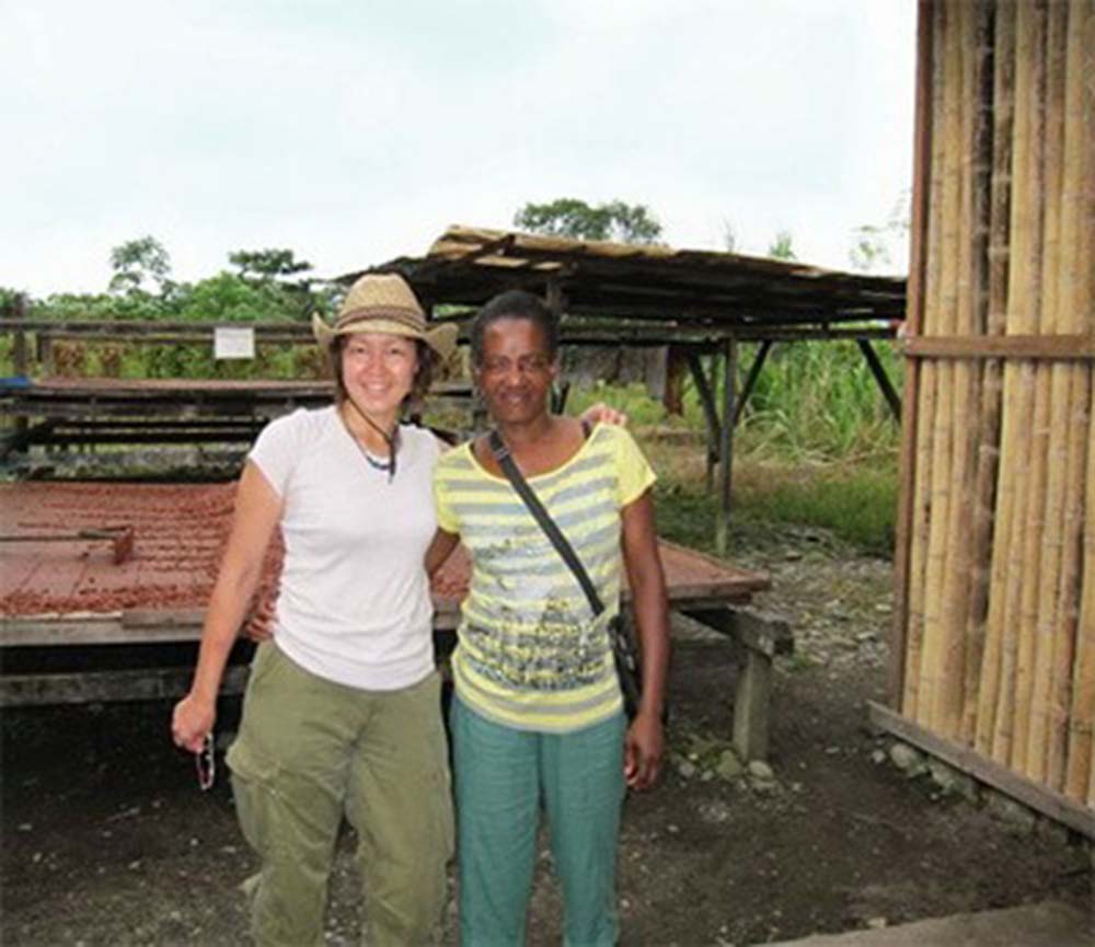 エクアドルとの国境近く、コロンビア・トゥマコのカカオ生産者と共に。後ろに見えているのはカカオの天日乾燥台。