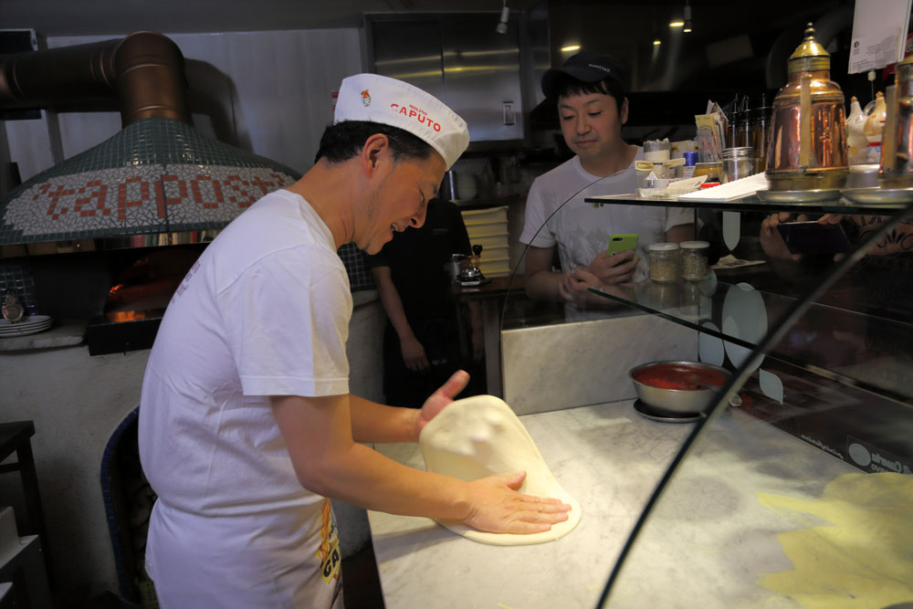 滑らかな手つきで生地を伸ばす。生地温度を上げないために作業はスピーディーに行う。