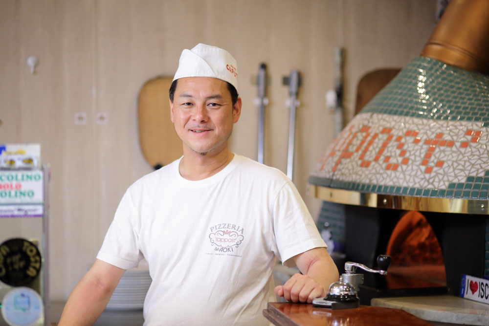 青木嘉則さん ナポリのイスキア島にある名門ピッツェリア「ダ・ガエターノ」に弟子入りし、その技を継承する。1999年、豊島園に「ピッツェリア ダ・アオキ タッポスト」を開店。10年3月には、同駅前にバールと酒販店、惣菜店を兼ねた「タッポスト チャオラ」を開く。