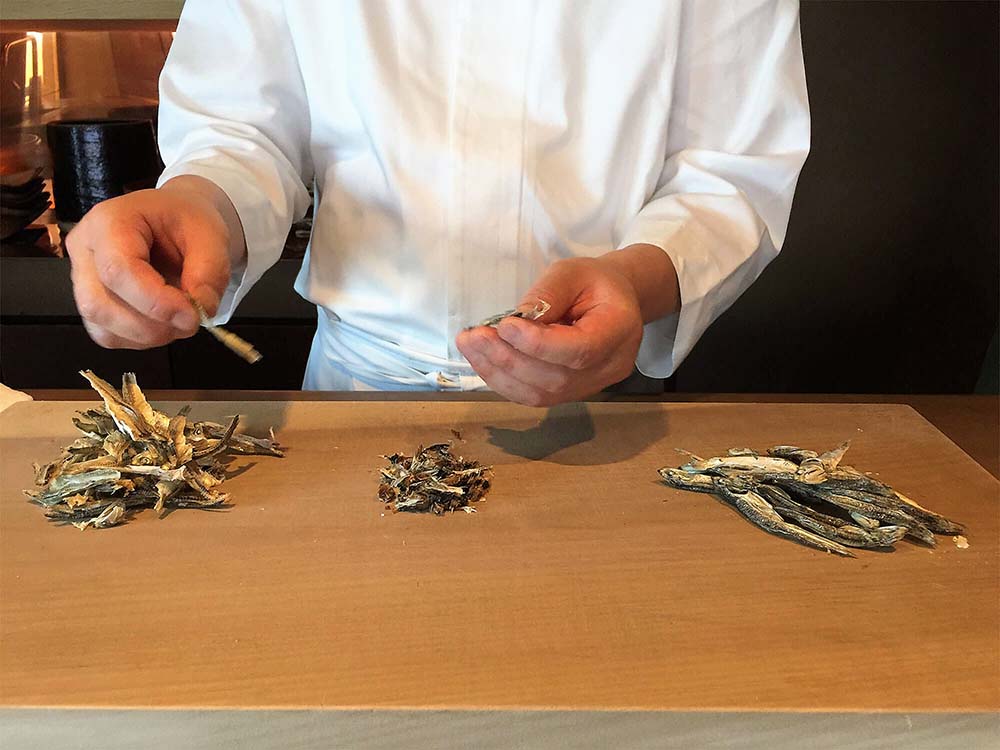 手にしているのは香川県観音寺市「やまくに」のいりこ。「とにかく質が良い。銀色に光って、パカッときれいに割れる」。にゅうめんのだしの他、ぬたの和え衣にも使う。「これは大羽。中羽が理想だけれど、最近、獲れないらしくて。もし、中羽が手に入ったら、椀物のだしもいけるんじゃないかな」。