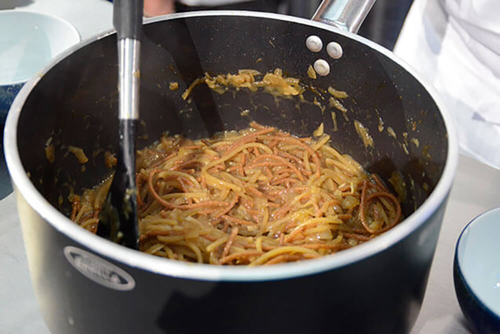 茹でたパスタと一緒にタマネギ、アンチョビーのソースを絡める。