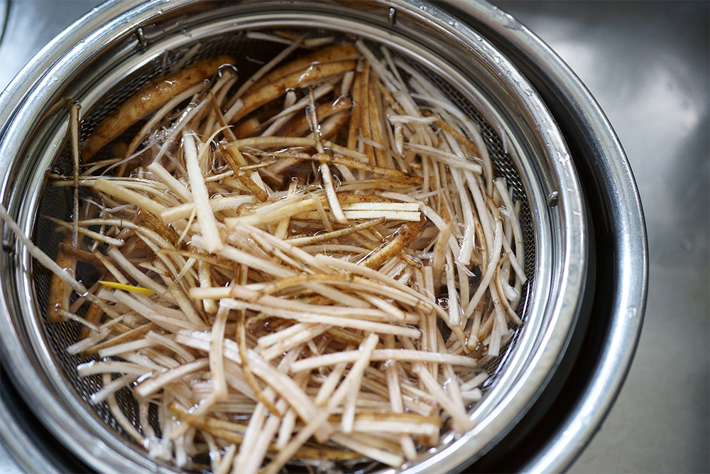 （A）きんぴら用は厚さ2.3 ㎜・幅３㎜のスライサーでせん切りにし、端は４～６等分に押し切りにして、食感の違いを楽しむ。