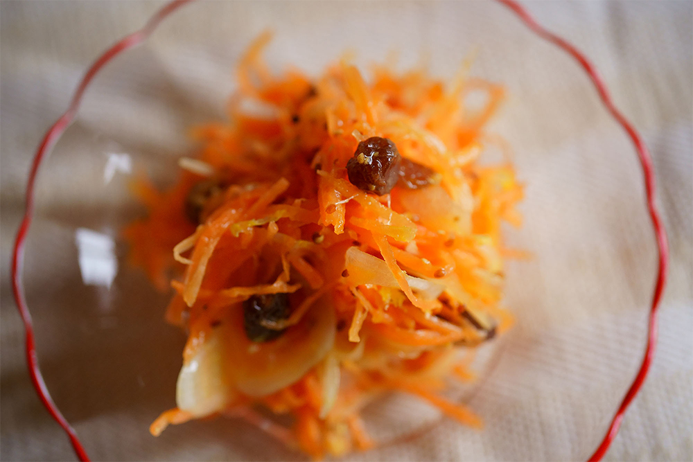 ふんわり味が染み込んだキャロット・ラペ ふんわりした切り口。断面はギザギザしていて、味が染み込みやすい。岡田さんがラペ用として日本でやっと見つけた、ののじ社の「サラダおろしBOX LBG-01GW」でおろしたもの。刃は裏表で６mmと３mm幅があり、ラペには３mmを使う。
