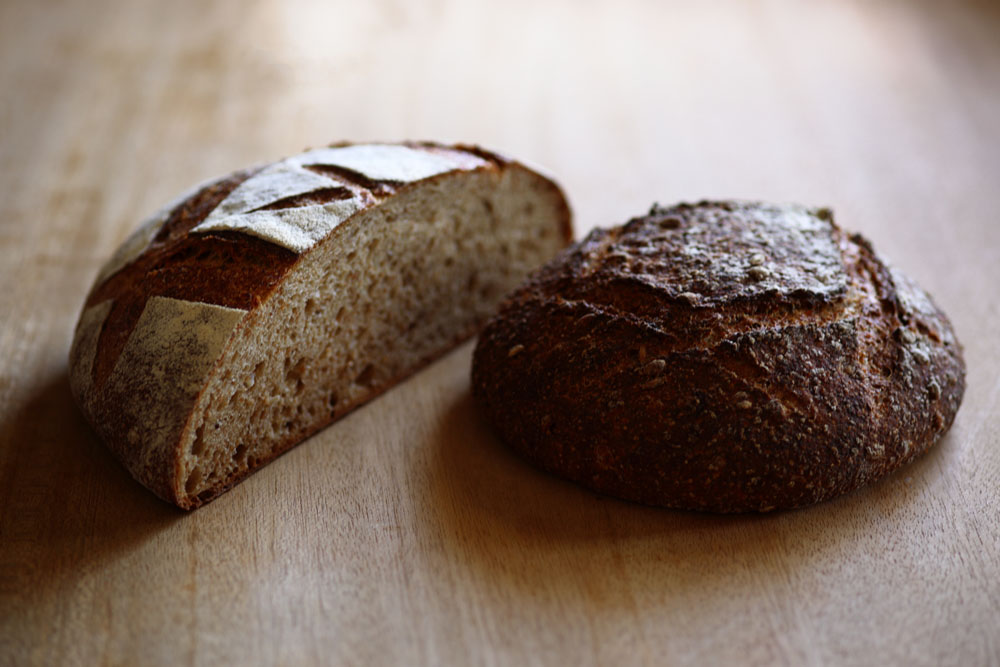 （左）「パン・オ・ルヴァン」は北海道産の小麦やライ麦を主体に、すみや農園の有機農林61号ふすま４％、福田農園の石臼挽き有機ライ麦全粒粉6％を配合。 （右）すみや農園の小麦全粒粉40％のパン・コンプレ生地にキヌア、アマランサス、スペルト小麦を混ぜた「古代穀物のパン」。毎年少しずつ増やしているが、使用する粉の全量を地粉でまかなうところまではまだいっていない。