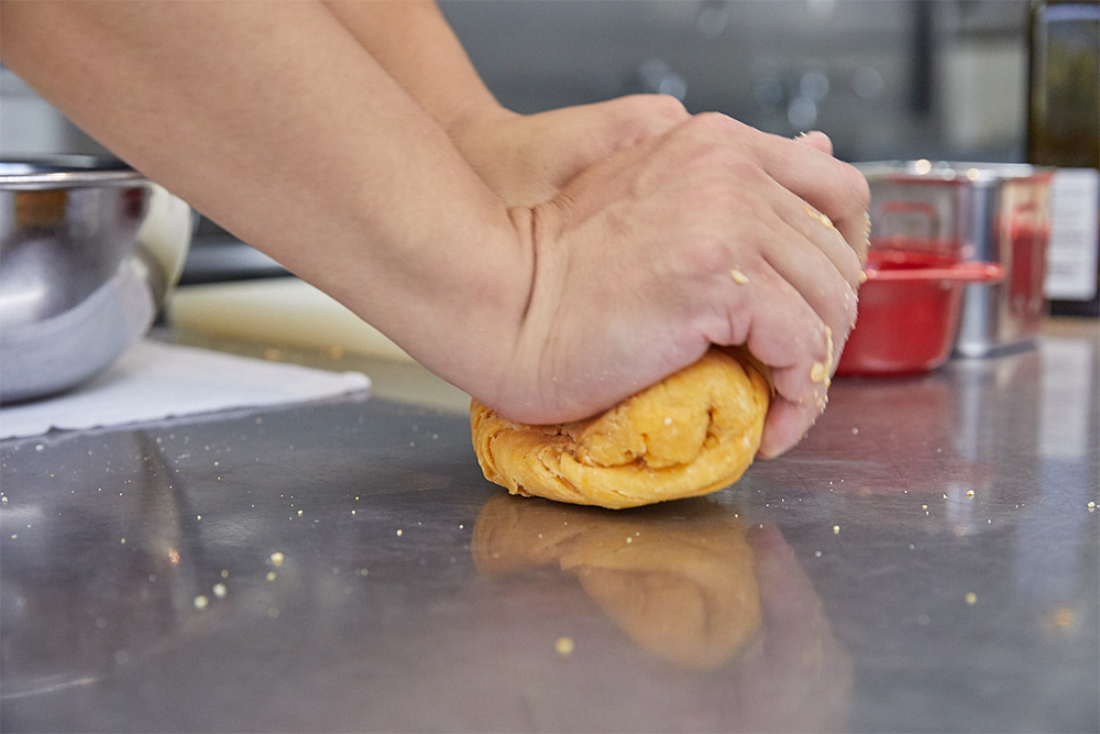 「おいしくなあれと愛情を込め、腰を入れて捏ねる」と辻シェフ。