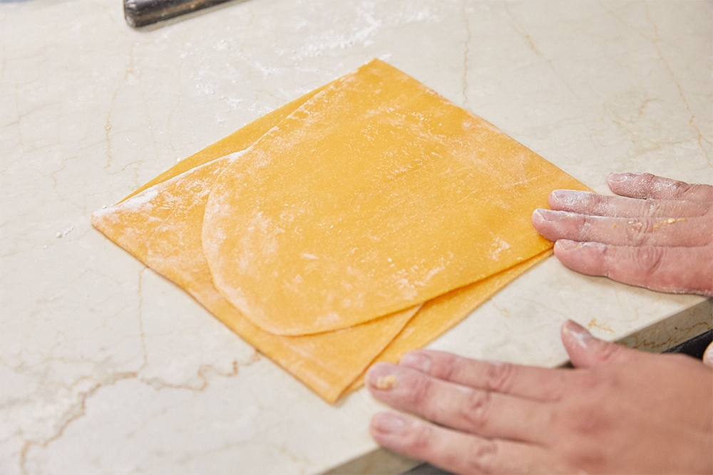 生地をパスタマシンに３度ほど通して長く伸ばしたら三つ折りにし、向きを変えてさらに伸ばす。