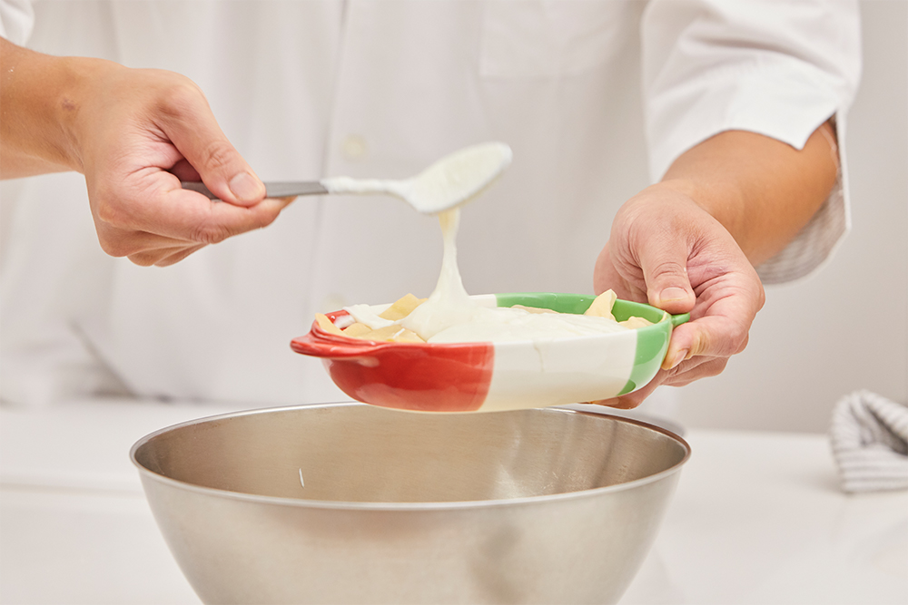 最後に加えるベシャメルソースは、パスタを覆い隠すくらいたっぷりと。さらにグラナ・パダーノをかけてオーブンで表面に焼き色を付ける。