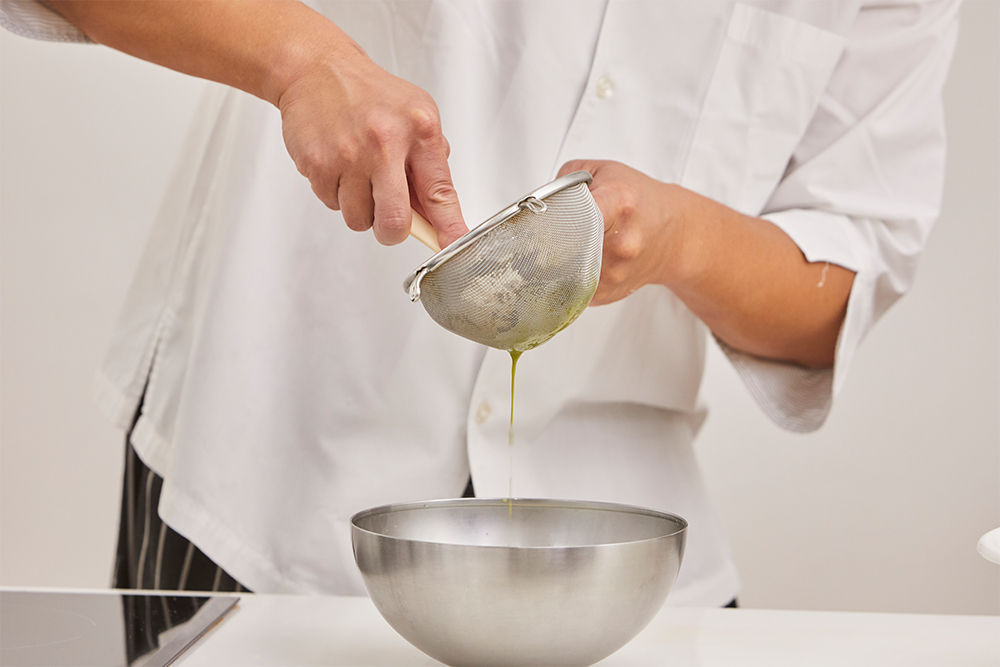 緑茶を蒸らし終えたら、ゴムベラでぎゅうぎゅうと押して、最後の一滴までしっかりと漉す。「乳製品の甘味と合わせるので、しっかり渋味のあるお茶を選ぶといいです。焙じ茶や、カモミールやラベンダーなどハーブティーもよく合います」