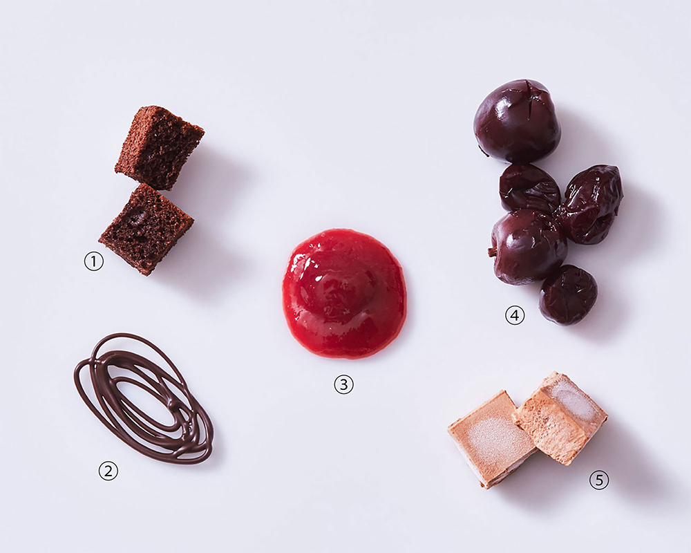 トッピングの程よい酸味や苦味が、コク深く上質なソフトクリームの味わいを際立たせる。①アーモンドを加えたチョコレートのビスキュイをキューブ型に、②ビターチョコレートで作った飾りパーツ、③甘酸っぱいチェリーのソースで仕上げて、華やかに、④チェリーのシロップ漬け、⑤ガナッシュ・モンテを凍らせてキューブにカット。