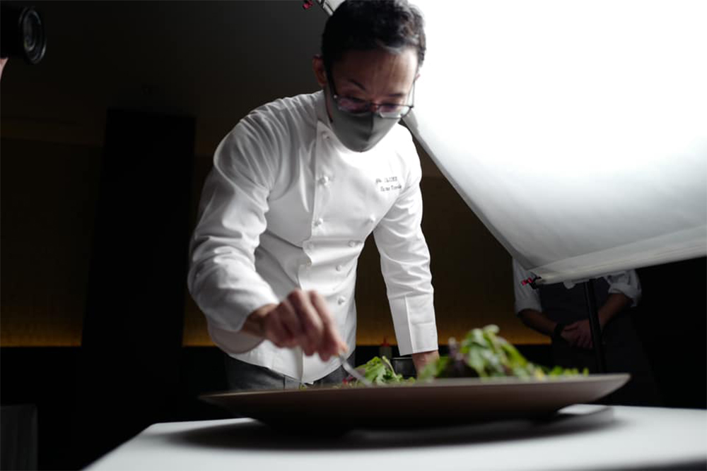 「Chikyu 地球」を盛り付ける米田シェフ。食べ進む順番を考えながら、調理法、温度、食感の異なる食材を緻密に組み立てる。「通る道が違っても同じゴールにたどり着くように調和を図る」