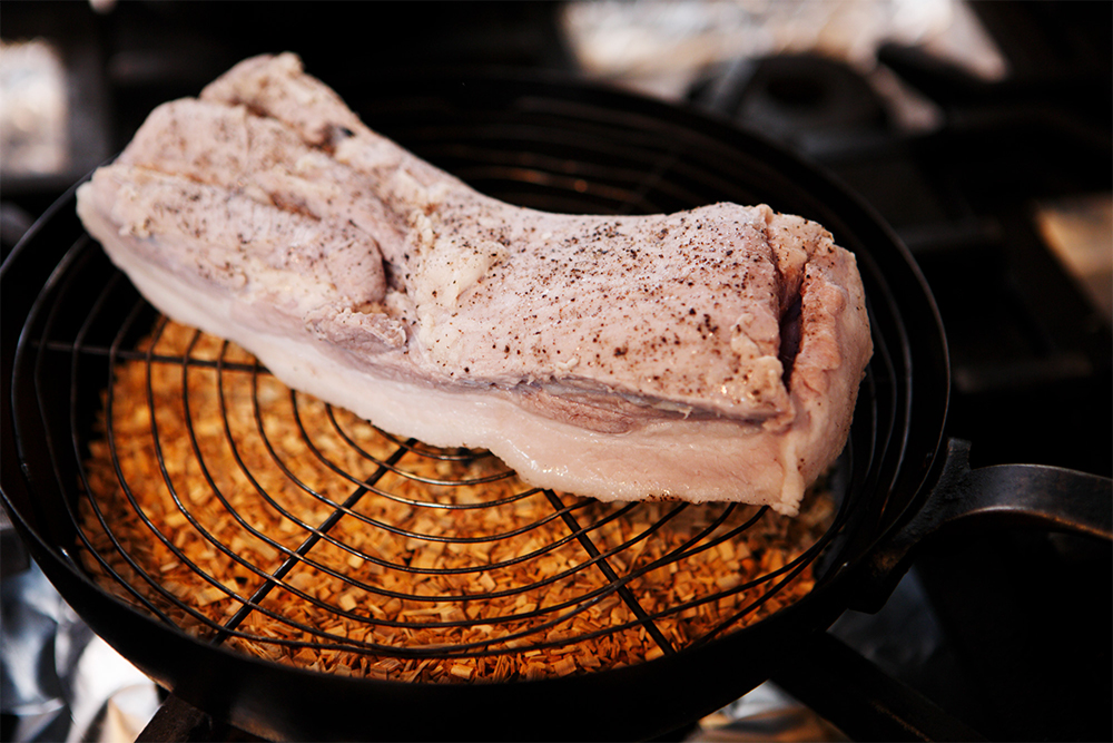 フライパンにチップを入れ、網を置いて強火にかける。煙が立ったら、脂を下にして置き、蓋をして弱火にする。