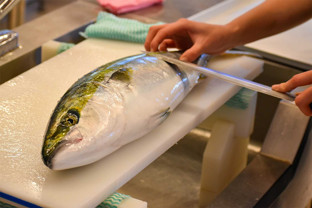 魚を捌く練習。周囲の海にいる魚が教材だ。生態を知った上で調理に取り掛かれるのが強み。