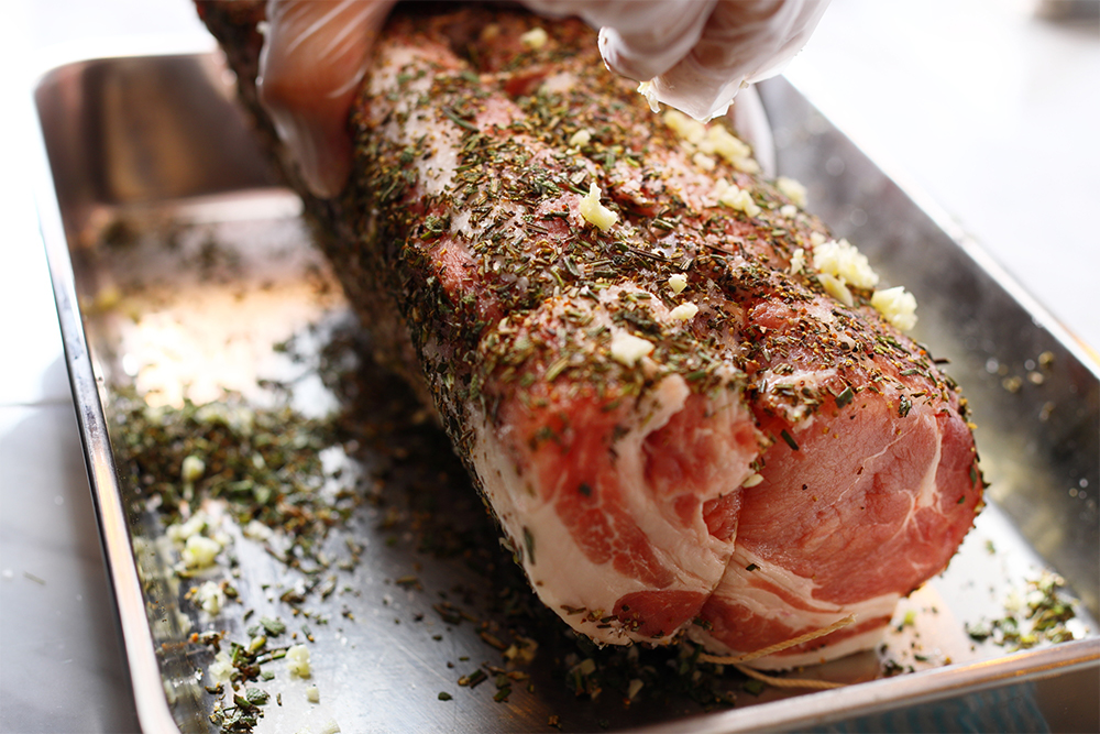 塊のロース肉は紐で縛ってから塩、ハーブ類を揉みこむ。