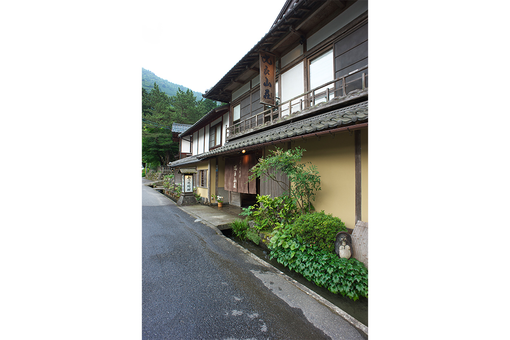 比良山系の山懐に抱かれるようにたたずむ「比良山荘」。きれいに掃き清められた店の前の、水路を流れる水も清らか。