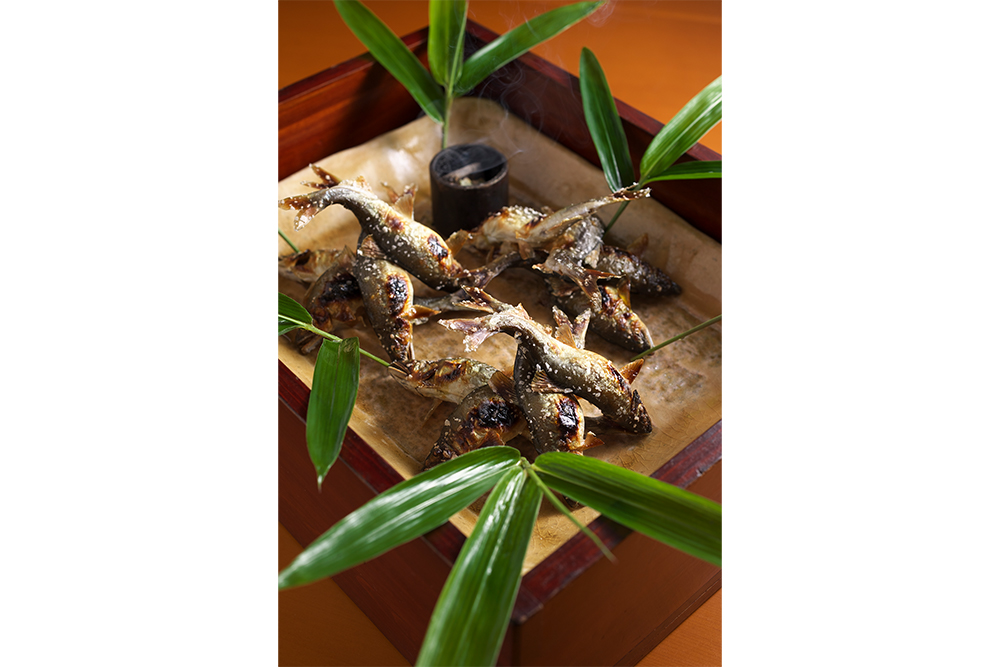 6月の鮎解禁を待ち焦がれていた食いしん坊たちが、「鮎食べコース」目がけて全国からやって来る。コースの華はもちろん塩焼き。3尾、2尾、2尾と、3回にわたって供される。乾燥させた笹の葉をいぶしながら運ばれてくる。この香りで、食欲は全開に。鮎食べコース15000円、20000円（税サ別）。