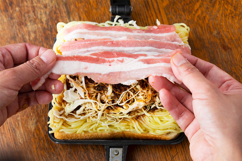 【２】キャベツ、残りのソース、肉の順に重ね、バウルーの蓋をする。