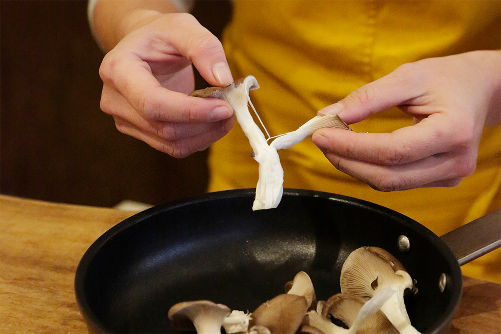 ヒラタケを手で裂き、テフロン加工のフライパンにぎっしり並べる。