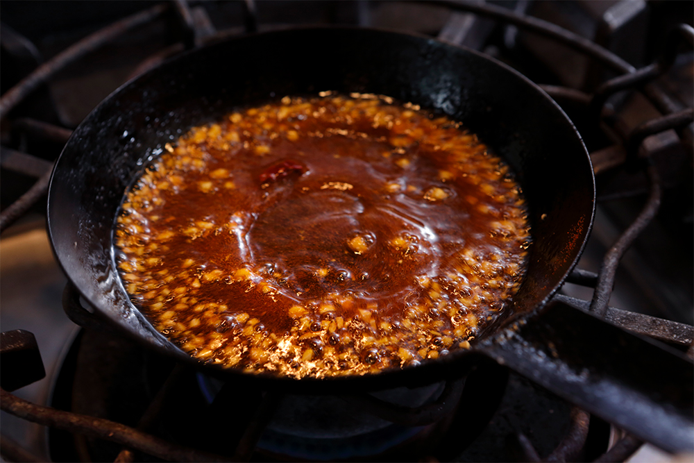 香りが立ったら、ピメントンを加えて香りを移す。