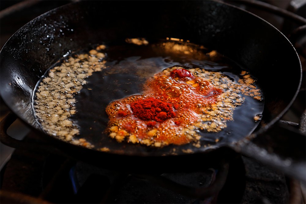 レフリートを用意する。小さなフライパンにオリーブ油と一度潰してからみじん切りにしたニンニクを入れ弱火にかける