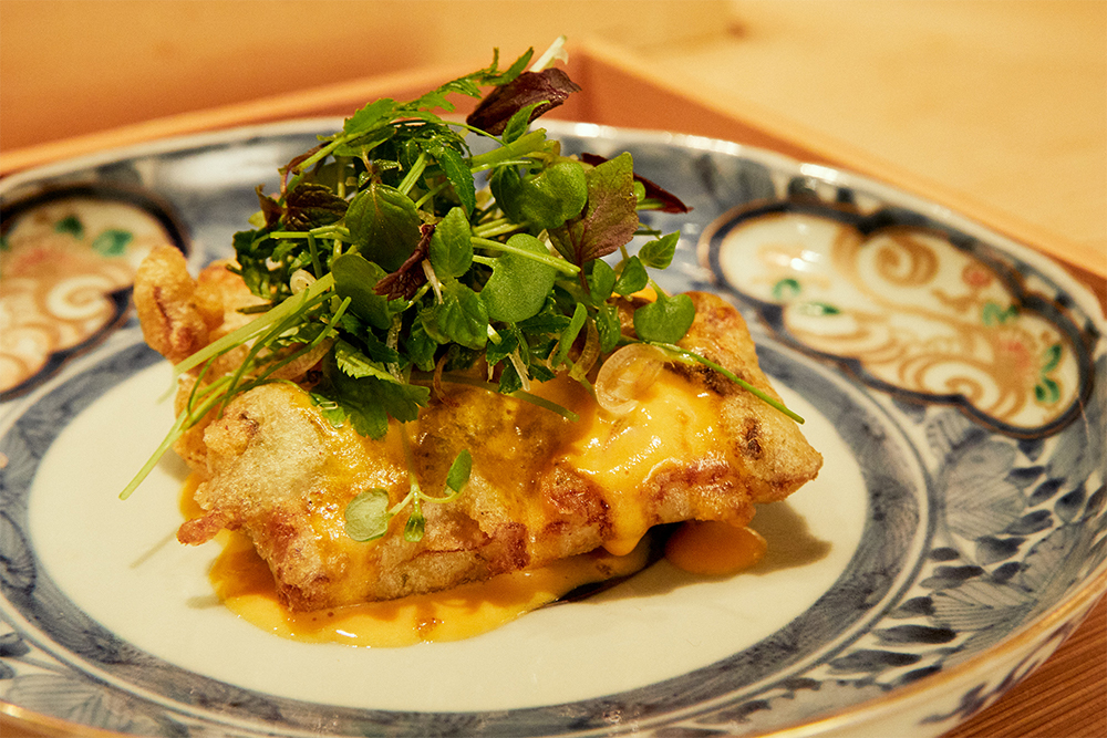 敬愛する生産者のオーガニック鰻は、清流を思わせるきれいな旨味。フィッシュ＆チップスをヒントに、軽快なフリットに。黄身酢のコクを添え、シャブリとの繊細なバランスを図っている。