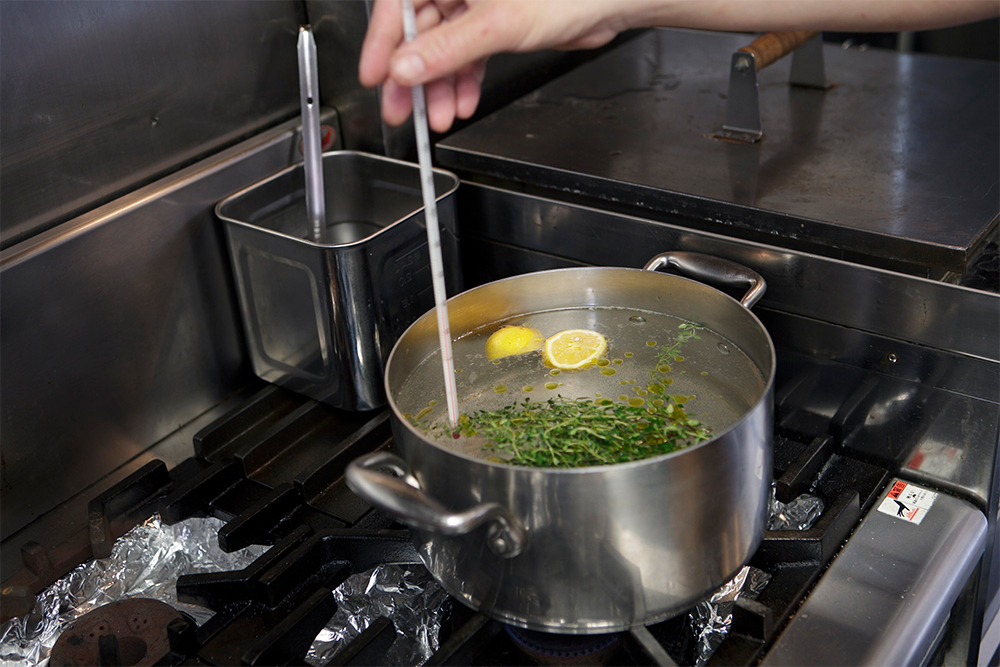 湯の温度が75℃になるまで温度計で計り、温める。