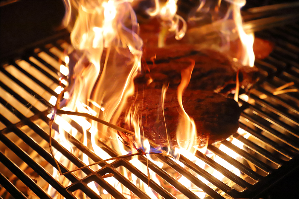 提供前にテラスで、藁の香り付けをする演出。