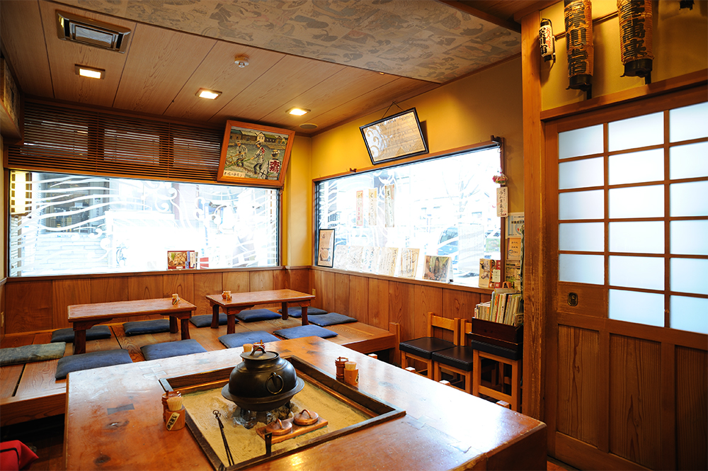囲炉裏を囲むテーブル席とお座敷のこぢんまりとした店内。