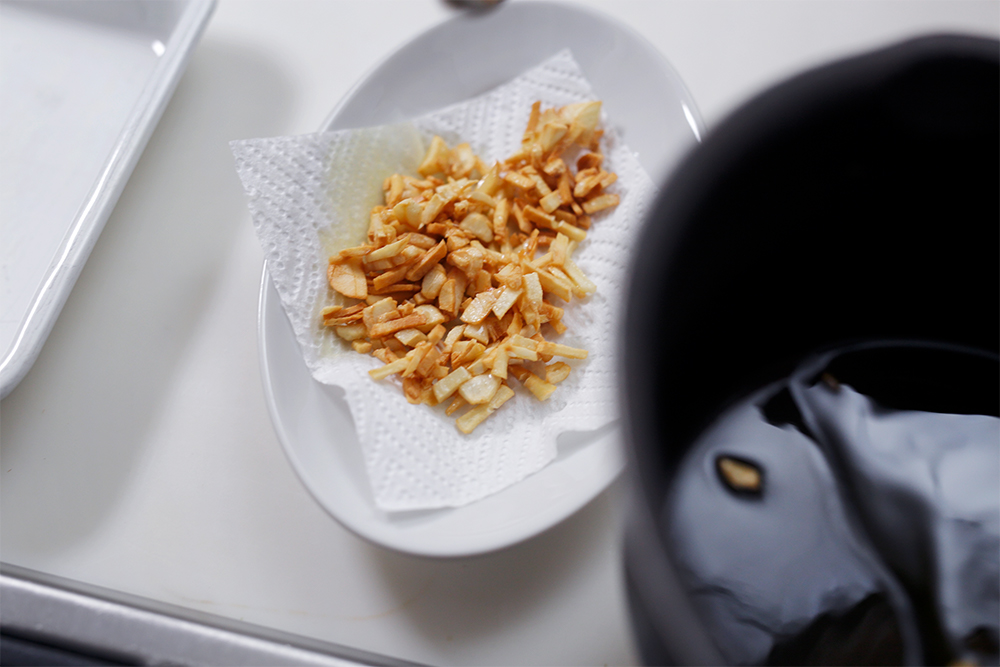 ニンニクの周りにシュワシュワと泡が出て、キツネ色になれば網で引き上げる（油を切ってとっておく）。