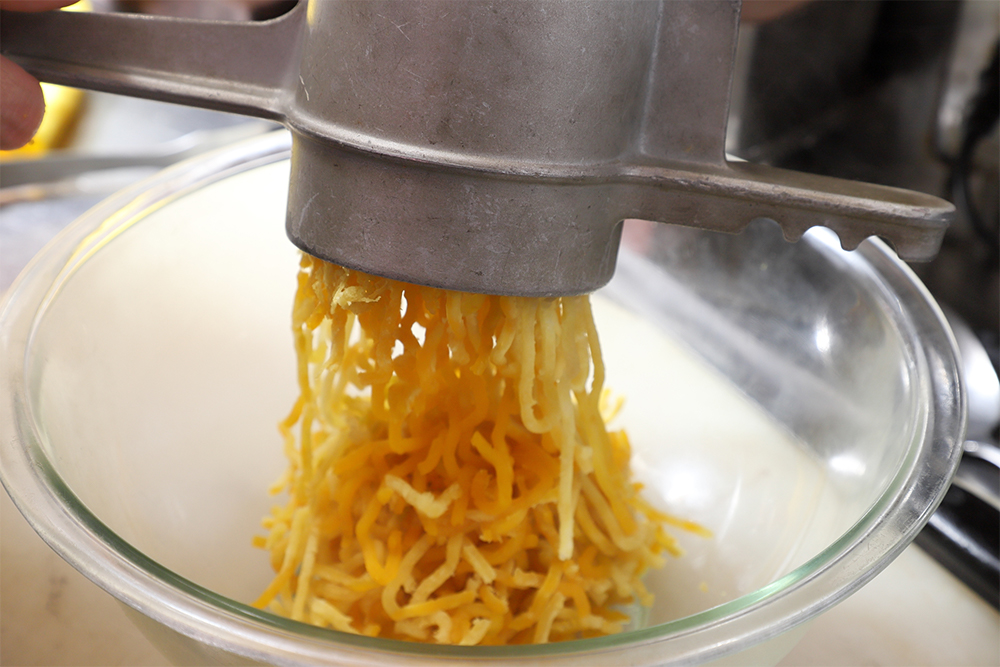 ２の根菜をザルに上げて取り出し、マッシャーで潰す。