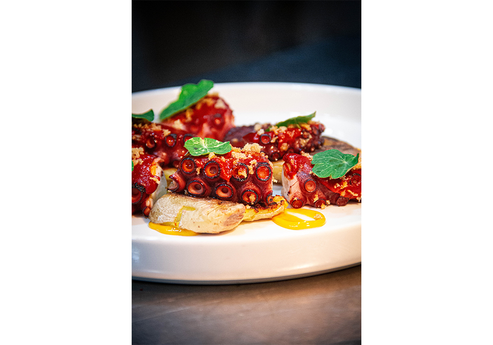 パパス（パプリカの乳化ソース）とロタス（潰したジャガイモ）を添えたタコの炭火焼き。