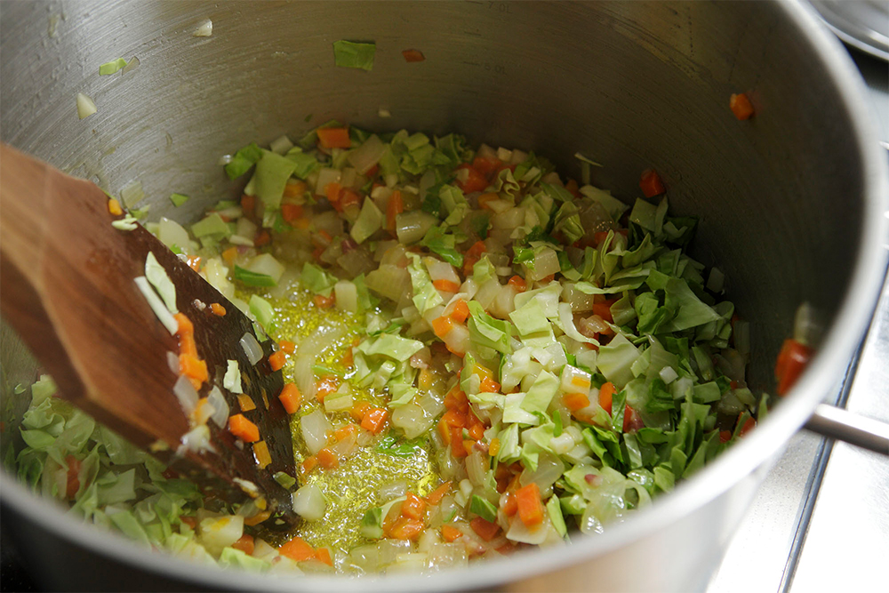 キャベツを粗みじんにして加え、炒める。中弱火で、「シュワシュワ」という軽い音が立つのを火加減の目安に。