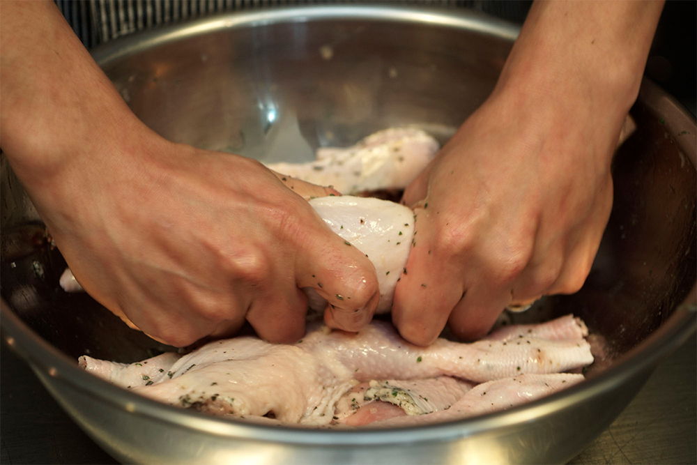 ●マリネ＝マッサージすること 肉をマリネする際、マッサージするように70～80回丁寧に揉み込む。気の遠くなるような手のかかる作業も、食べる人を思ってこそ。