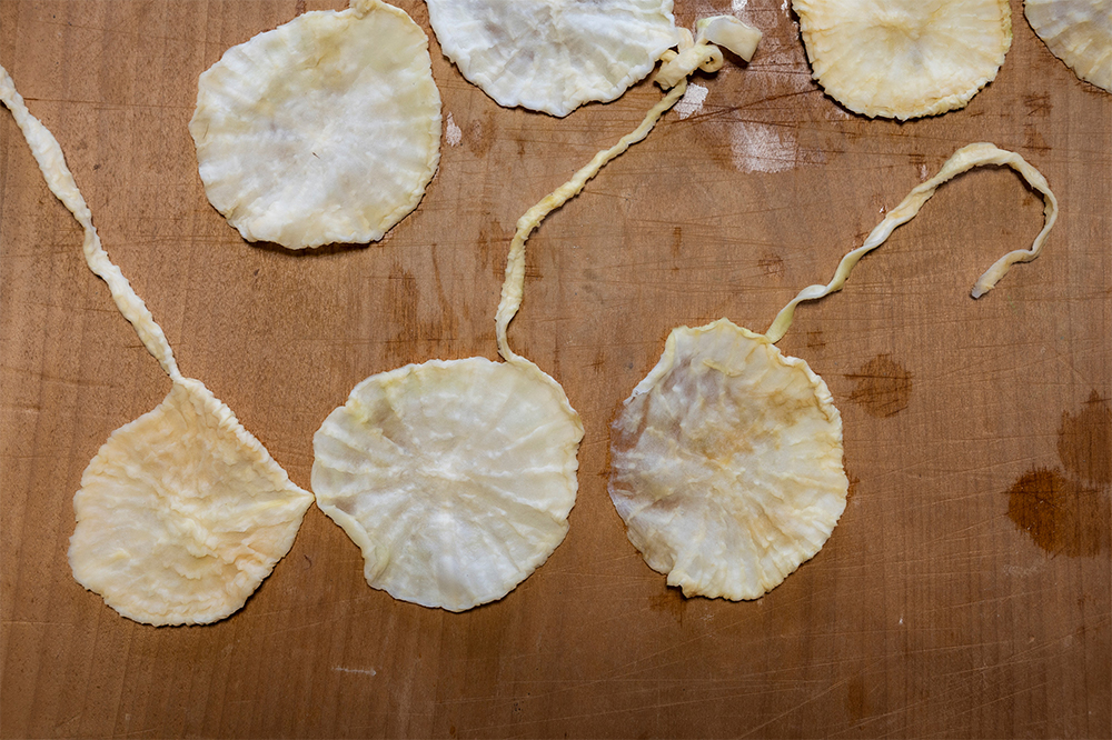 ３． 湯で戻す 大根を湯で軽く洗いながら戻す。軽く絞って水分をふき取り、広げる。