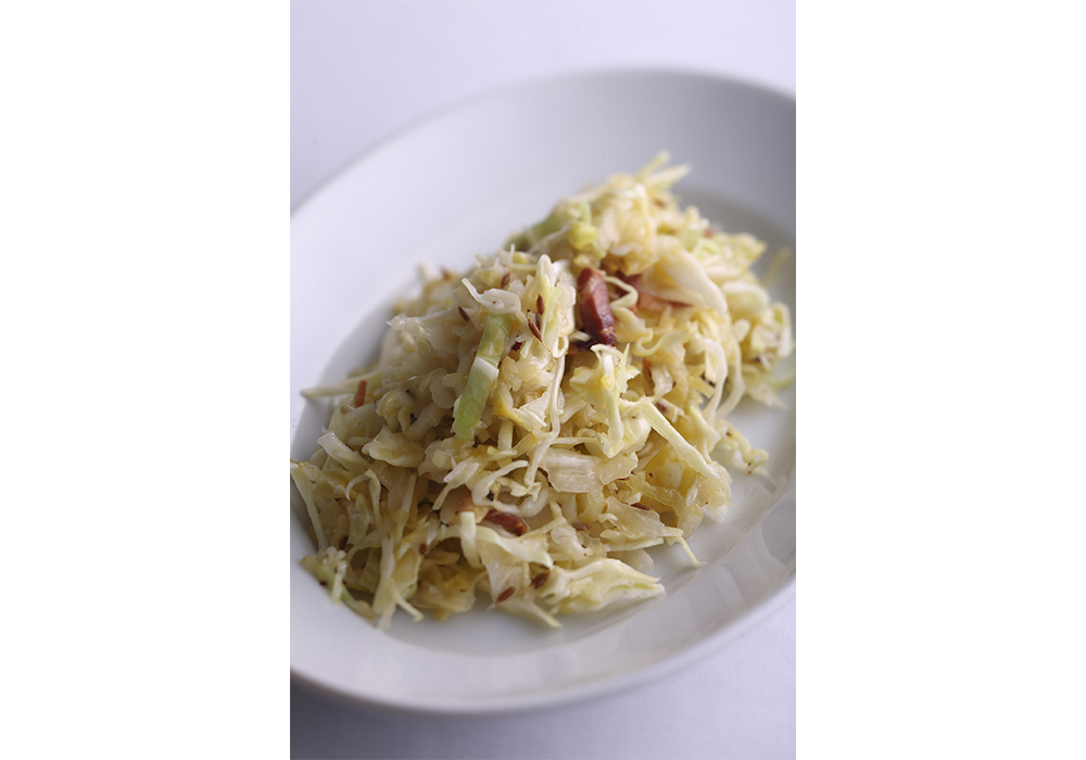 クラウティ、スペックとクミンのサラダ・・・せん切りのキャベツを加えればさっぱりとしたサラダに。カリッと焼いたスペック（燻製生ハム）とクミンで、旨味と香りをまとわせ、食欲をそそる味わいに。