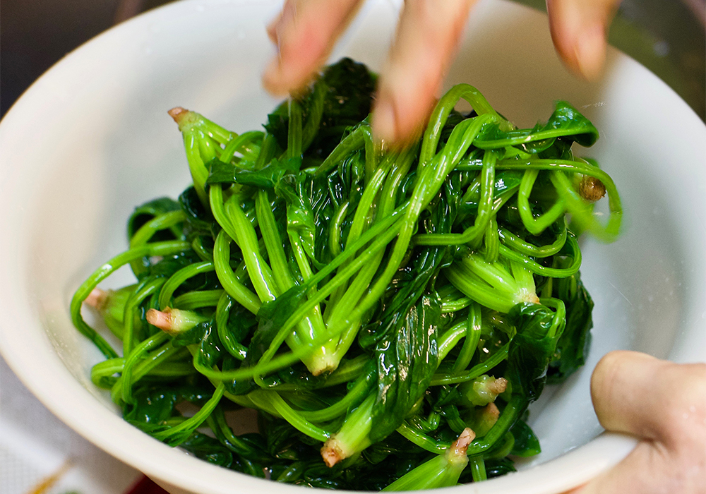 ホウレン草を持ち上げてボウルに移し、１株ずつ取り出して向きを揃え、４cm の長さに切る。POINTボウルに残った水分は捨てない。