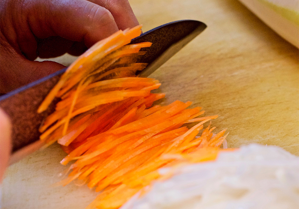 ダイコンは皮を剥き、薄い輪切りにしてからせん切りにする。ニンジンは斜めに薄くスライスしてからせん切りにする。POINT　スライサーは使わない