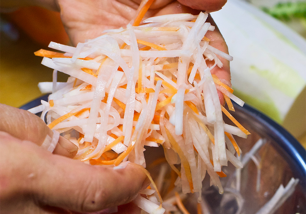 ダイコンとニンジンをボウルに入れ、塩を振って手で持ち上げるように優しく混ぜる。 POINT　塩分が抜けないので、塩加減は控えめに。