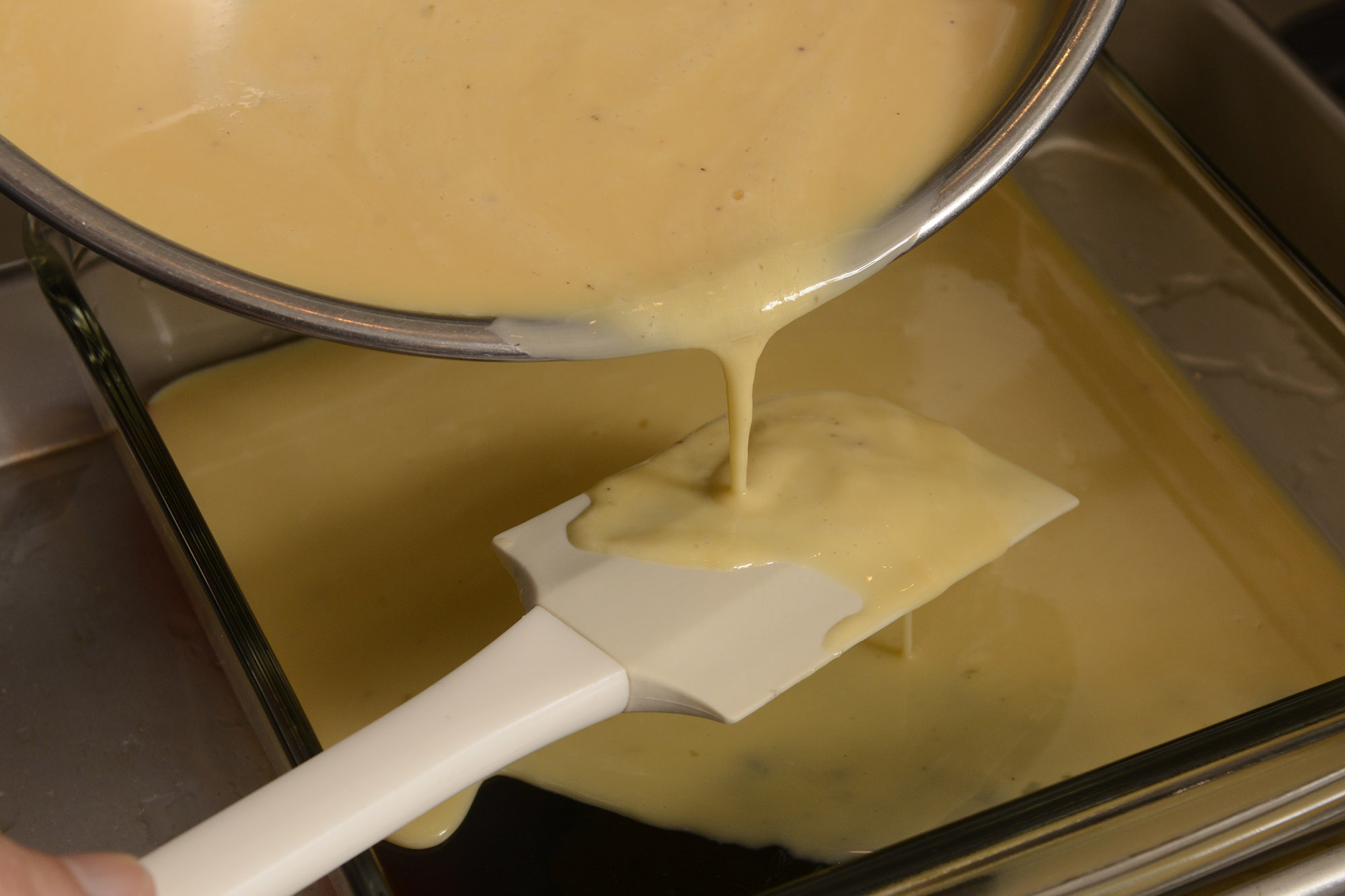 【９】ヘラでワンクッションおいて、卵液をゆっくり加える。