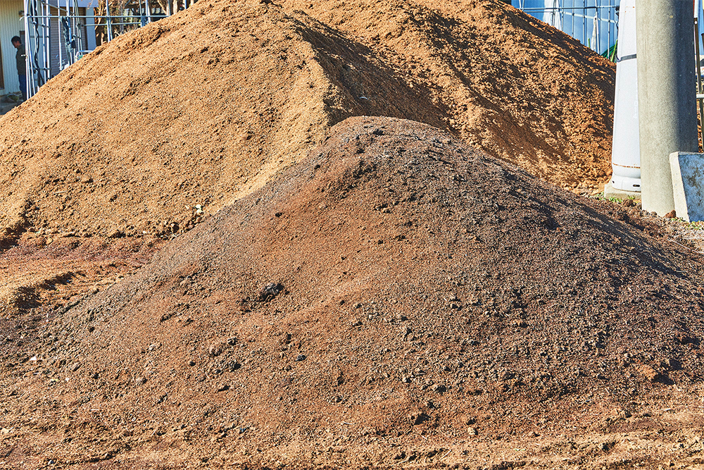 使用する肥料は、ブナマイタケの菌床と米ぬかをベースに独自で配合し、自然発酵。発酵を終えた肥料（手前）は、発酵中のもの（奥）に比べて色が深まり、においも和らいでさらさらの状態に。