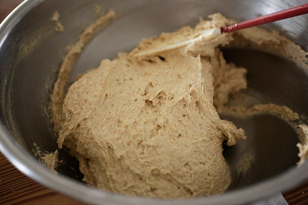 底からすくい上げるように力強く混ぜたり、上部の生地をやさしく混ぜたりして、生地をしっかりつなげ、なめらかでつやのある状態にする。ゴムベラに持ち替え、底からすくい混ぜてムラをなくす。 [９]クランブルを作る