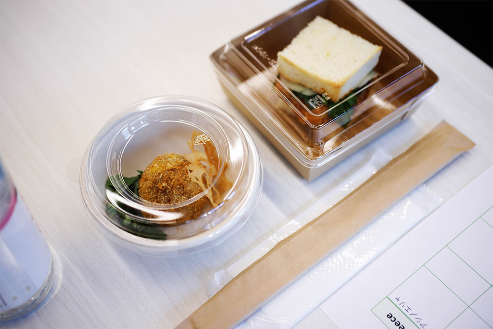 日髙シェフ考案の「ポルチーニと蓮根のアランチーニ」（左）、「ポーランド産牛肉のカツレツパニーノ」（右）を試食。テイスティング用のオイルを“追いオリーブオイル”して“味変”も体験。