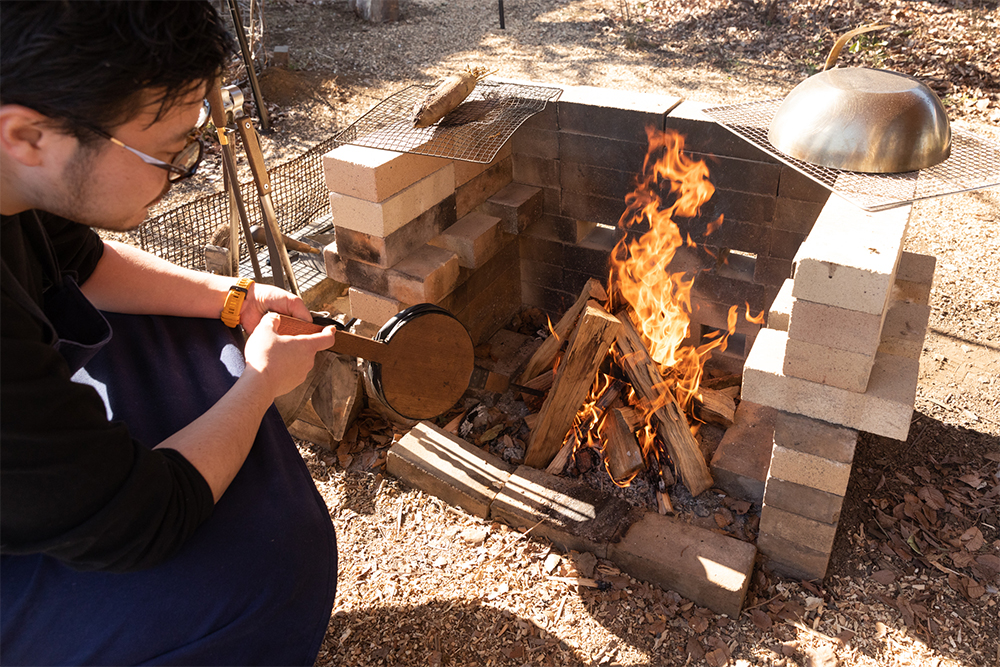 耐火煉瓦を自ら組んで作った炉。通気性や形状に加えて風向きも考慮されている。麻縄をほぐして枯葉や木っ端と共に種火を作って火を熾す。くべる薪を徐々に太くして、火力を上げていく。