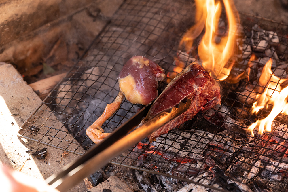熾火の上に直に網を置き、鴨の腿肉と胸肉をのせて表面をこんがり焼く。鴨の脂が火に落ちると煙が上がり、肉が脂と煙をまとう。