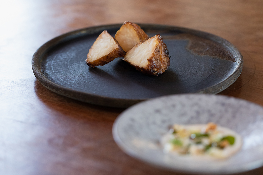 根セロリの低温ロースト 自家製サワークリーム、燻製大根の薄切りと大根葉のオイル、生クルミ、フェンネルのソース添え