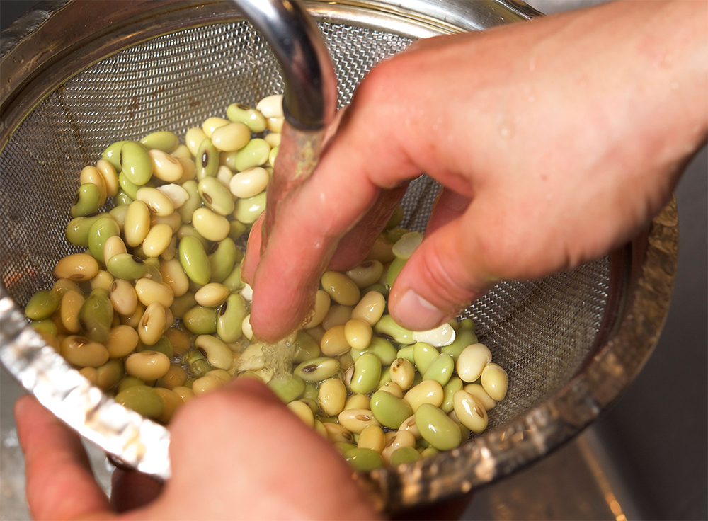 [４]水洗いする ザルにあけて湯を切り、軽く水洗いする。鍋も洗う。
