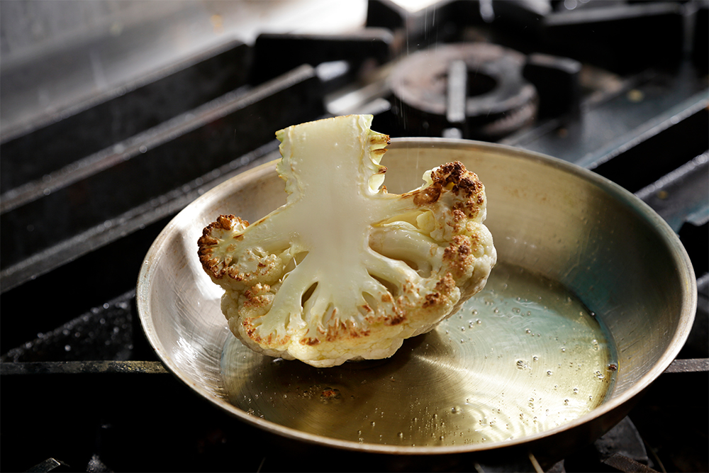 表面を焼いたら、180～200℃のオーブンでこんがり焼き色がつくまで焼く。この状態まで仕込んでおいてもよい。 POINT：フライパンで焼くことで早く火が通る。時間がない時は揚げてもよい。 ［４］香味野菜で風味アップ