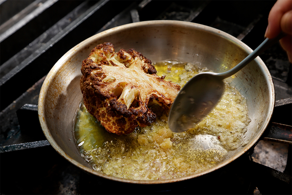 フライパンを火にかけ、ニンニク、エシャロット、スパイスミックスを加える。 ［５］アロゼでシェフの味に！