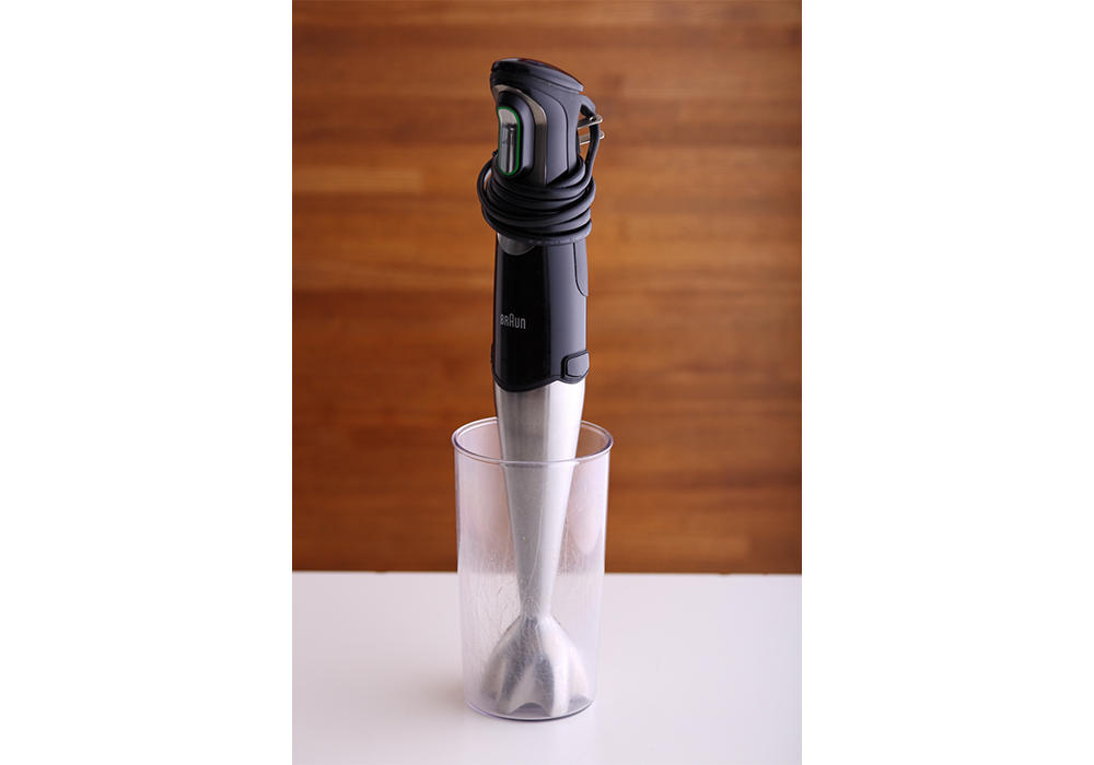 ［道具のポイント］ ハンドブレンダー。鍋の中にそのままハンドブレンダーを入れても、キャベツが逃げて撹拌がしっかりできないため、付属の細い容器に移して行う。竹内シェフのブレンダーだと、３分半ほどでビロードのような食感に。メーカーによってパワーの差があるので、最終的な仕上がりは自身の舌で確認すること。